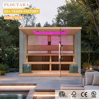 Ruang Sauna Luar Ruangan PLOUTARA dengan Dinding Kaca Panoramic, Dua Tungku Sauna, Dinding Belakang Batu, dan Lampu LED Ambient untuk Proyek Resor