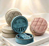 Boîte à bijoux ronde portable haut de gamme faite à la main en tissu velours avec matelassage diamanté, fermeture magnétique et compartiments intérieurs.