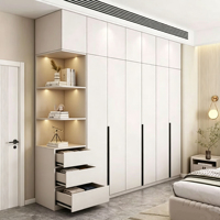 Armoire sur mesure minimaliste moderne du sol au plafond, blanche, intégrée pour chambre à coucher, avec éclairage LED, étagères ouvertes, tiroirs et poignées longues noires