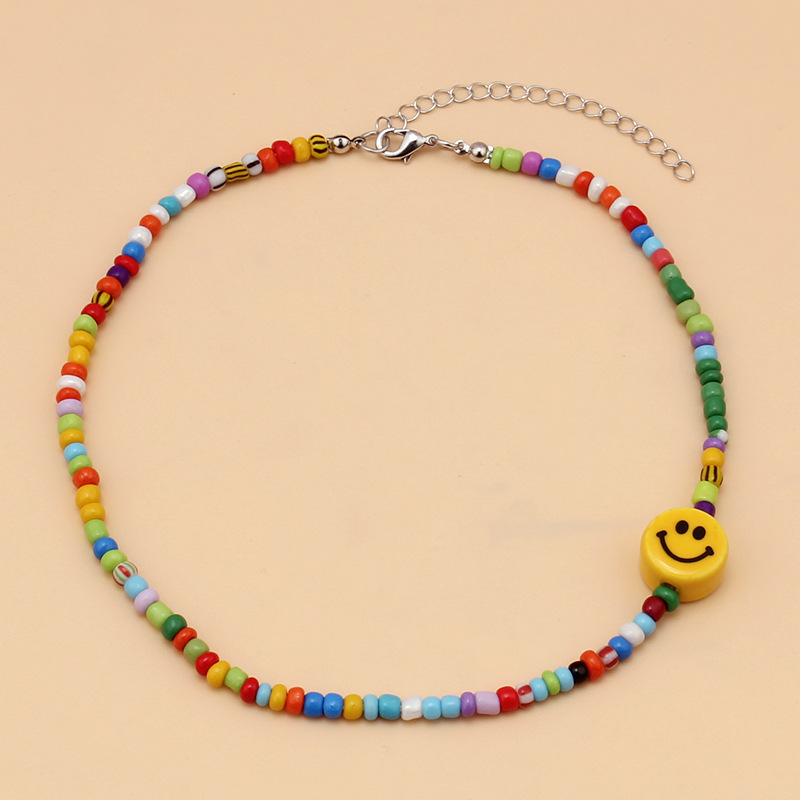 Collar de cuentas de semillas coloridas con caritas sonrientes.