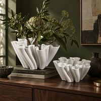 Vase en céramique blanche avec un design sculptural fluide pour fleurs et décoration intérieure