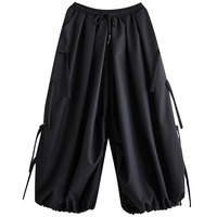 Pantalon large noir à taille élastique avec cordon de serrage et détails latéraux, coupe ballon, cheville froncée, style streetwear, collection automne 2026, vente en gros