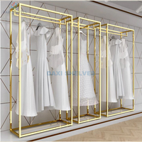 Présentoir à vêtements doré personnalisable pour magasin de vêtements, avec étagère à chaussures et porte-sacs