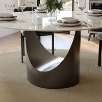 Table à manger ronde moderne, surface aspect pierre foncée, piédestal sculptural en U pour salle à manger