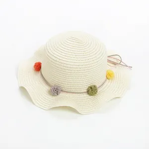 可爱的儿童圆顶波浪状帽檐与球花丝带草帽相结合