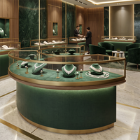 Vitrine à bijoux ovale, verre incurvé, finition verte, garniture en métal doré, éclairage LED pour les intérieurs de bijouteries haut de gamme