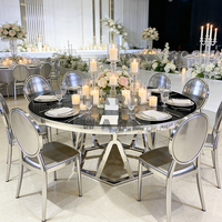 Table de salle à manger ronde de luxe avec plateau en verre noir, base géométrique argentée et structure en acier inoxydable