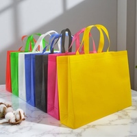 Sac shopping réutilisable en tissu non tissé de luxe, avec logo personnalisé imprimé et poignées en tissu, pour l'emballage des boutiques de vêtements.