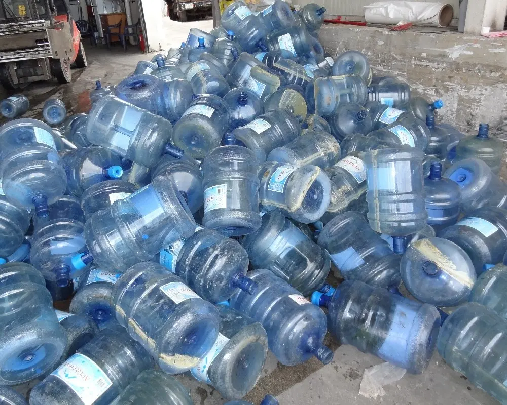 Botellas de agua de plástico PC (POLICARBONATO) Balas de color azul claro o chatarra molida/residuos para reciclaje.