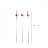 Brochettes de bambou élégantes avec boule rouge idéales pour le piercing sophistiqué de l'apéritif de la restauration