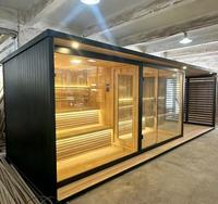 Sauna extérieur moderne avec douche de pluie intégrée, plateforme en bois, cadre noir, porte en verre, chauffage en pierre pour jardin et cour arrière