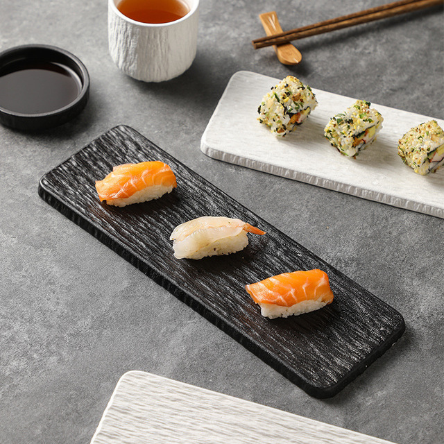 Handcrafted Japanese volcanic rock sushi plate with a natural black stone finish for professional sashimi presentation