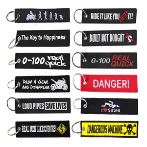 Ofrecemos una variedad de llaveros bordados para motocicletas con el eslogan Remove Before Flight y aceptamos personalización.