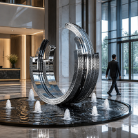 Sculpture d'anneau creux en acier inoxydable poli effet miroir, au design moderne et élégant, pour espaces extérieurs tels que parcs et places publiques