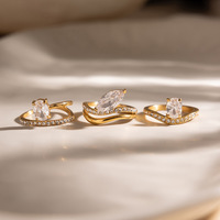 Cincin jari bergelombang bertumpuk dengan permukaan cermin poles premium, warna emas 18K, bertabur rhinestones berkilauan, untuk tampilan pesta koktail.
