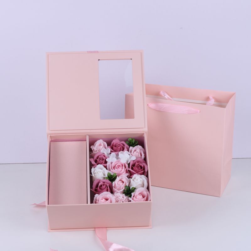 Boîte d'emballage rose avec sac à main et fleur