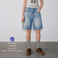 Shorts en jean vintage effet délavé, avec sangle de taille arrière réglable à boucle, coupe ample et jambe large pour femme, idéal pour un look décontracté ou urbain.