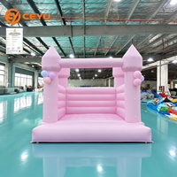 Château gonflable rose pastel Ceyu avec tour de cônes et grappe de ballons pour fêtes d'enfants, mariages et événements à louer