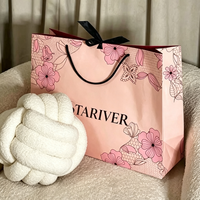 Sac en papier personnalisé imprimé rose clair avec laminage brillant, poignées en corde noire et doublure intérieure rouge pour l'emballage de vêtements féminins