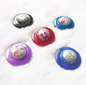 Paillettes de couleurs mélangées de 14mm dans une colle ronde en résine sur un ongle et une colle opaque à dos plat sur une boucle d'oreille comme décoration en vente