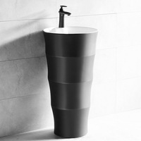 Lavabo sur pied design en céramique et ciment pour salle de bain, avec comptoir en surface solide noire