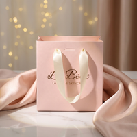 Emballage cadeau boutique classique avec logo personnalisé, petit sac en papier rose avec poignée en ruban