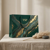 Sac en papier vert émeraude de luxe personnalisé avec texture marbrée dorée fluide pour parfums et cosmétiques haut de gamme