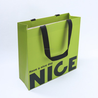 Maßgefertigte Grüne Papier-Geschenktüte mit Schwarzem Bandgriff Slogan-Druck Modische Verpackung für Einzelhandel Kosmetik Geschenkeläden