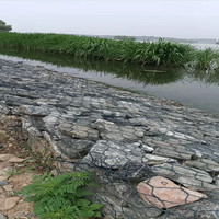 Matras gabion yang diisi batu di lokasi proyek untuk membentuk jaring kawat heksagonal ganda yang fleksibel dan permeabel.