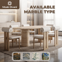 Ensemble de table à manger ovale en pierre texturée italienne avec chaises à dossier roulé géométriques et coussins blancs pour un intérieur de style crème