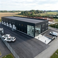Atelier préfabriqué en structure métallique avec bureau, composants et plans de chantier