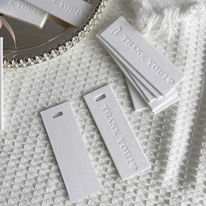 En stock – Étiquettes volantes en coton 9x3cm avec logo gaufré « MERCI » pour vêtements et cadeaux – Accepte la conception personnalisée - Product Image 1