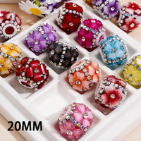 Strass en forme de cœur de couleur fluorescente, associés à un pendentif en métal argenté en forme de fleur et à une chaîne de perles demi-perles.