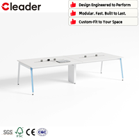 Table de conférence blanche avec pieds en métal, pilier central et système de rail électrique pour un bureau moderne au design minimaliste
