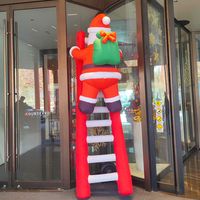 Sac cadeau géant gonflable personnalisé Père Noël grimpant l'escalier, en tissu Oxford durable et résistant au soleil pour centres commerciaux et Noël en extérieur