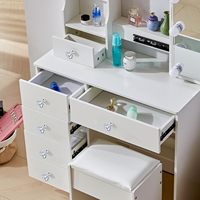 Chambre à coucher de style moderne avec une coiffeuse en bois blanc. Le miroir est équipé de 10 ampoules et de 6 tiroirs.