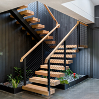 Escalier intérieur moderne à monopoutre avec garde-corps en câble et marches en bois massif