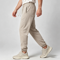 Pantalon de jogging fuselé beige pour homme avec revers côtelés, poche plaquée pentagonale, taille élastique avec cordon de serrage, poche oblique et fausse braguette, style décontracté