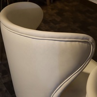 Table moderne de luxe avec plateau en pierre brillante et base en métal doré, accompagnée d'un fauteuil en cuir pour restaurant