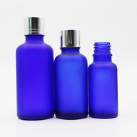 Flacon vide en verre bleu cobalt givré avec bouchon à vis argenté pour l'emballage de liquides cosmétiques et d'huiles essentielles