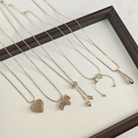 Collier pendentif vintage doré pour femme, avec breloques mignonnes en forme de cœur, nœud, croix, trèfle, collier ras-du-cou perlé, chaîne de pull, cadeau bijou
