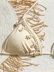 Bikini de mujer con parte inferior de tanga acanalada, ribete de encaje y dijes de concha, color beige. - Product Image 3