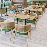 Ensemble de meubles de café moderne, restaurant, tables carrées en bois, chaises en rotin avec coussins verts et banquette en cuir vert