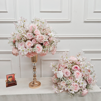 Centres de table floraux élégants roses et blancs sur un support doré, idéaux pour les mariages et événements romantiques.