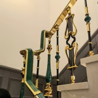 Colonne d'escalier monobloc en cuivre et aluminium, style luxe léger, avec main courante et garde-corps, fixation au sol, design moderne et minimaliste
