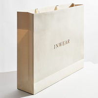 Sac cadeau en papier pour vêtements de luxe de marque privée personnalisée avec logo et poignée en ruban