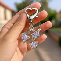 Porte-clés papillon orné de strass brillants avec mousqueton en forme de cœur pour la décoration des sacs à main et des sacs quotidiens