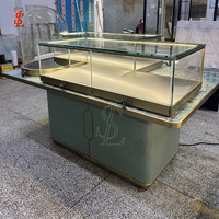 Comptoir de présentation de bijoux avec plateau en marbre, vitrine cloche en verre trempé, bordure en métal doré, table îlot, unités de présentation pour la vente au détail