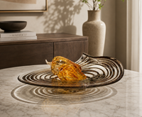 Luxueuze gedraaide spiraalvormige glazen schaal met amberkleurige tint voor fruitpresentatie in de woonkamer, op de salontafel of dressoir.