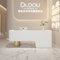 Comptoir de réception de clinique de soins de la peau de luxe moderne, comptoir incurvé minimaliste avec pieds dorés, bureau esthétique pour centre de beauté
